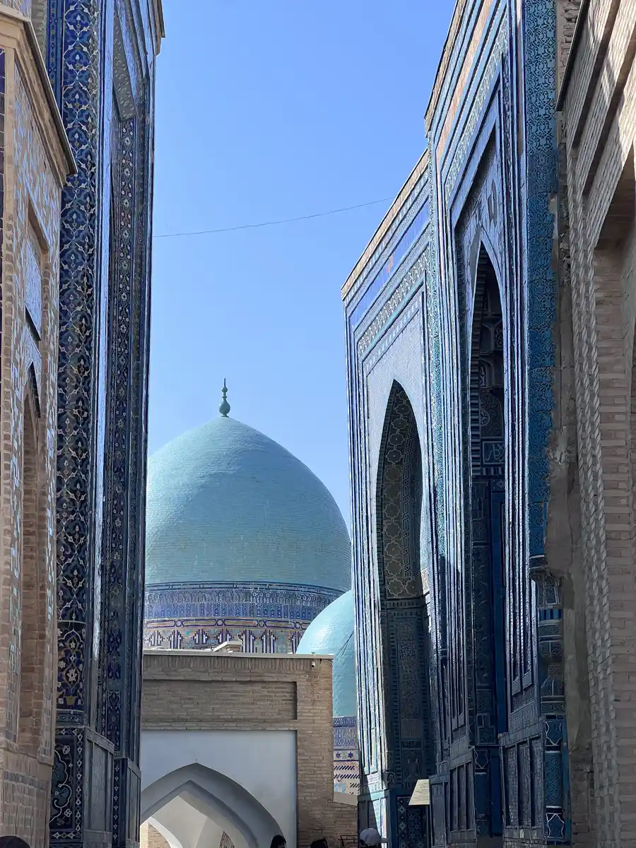 Turquoise dome of a Samarkand mausoleum framed between tiled entrance portals